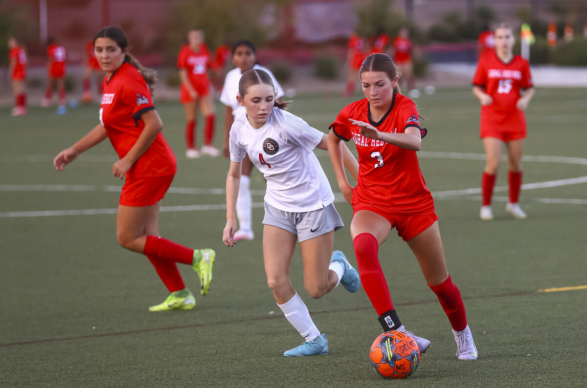 Doral Academy's Ryan Hedin (3) runs with the ball under pressure from Desert Oasis' A ...