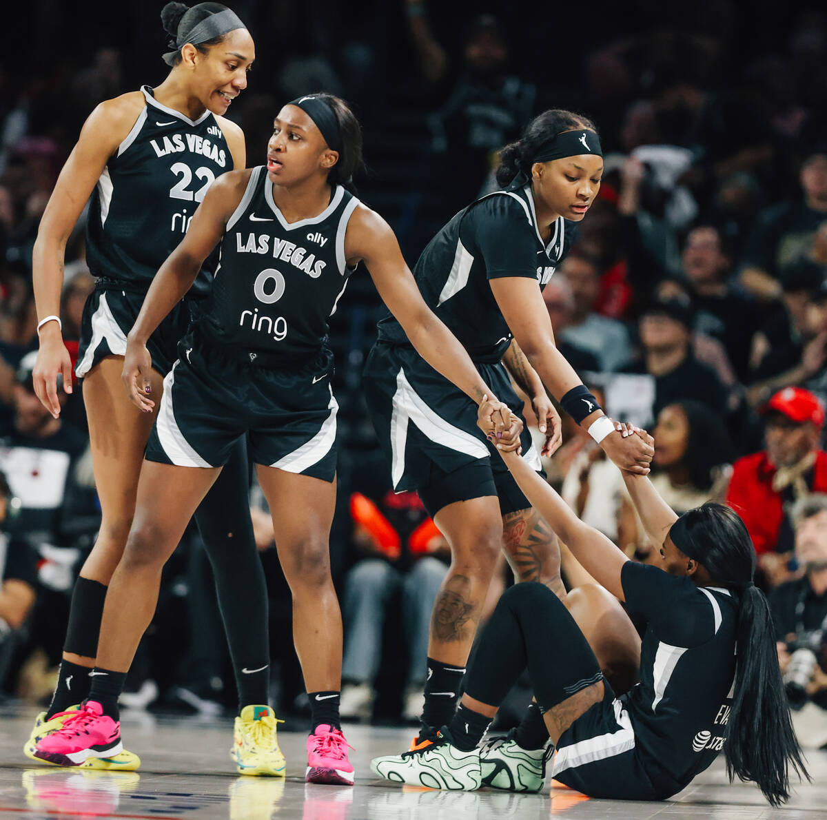 Aces guard Dana Evans (11) gets help getting up from her teammates during game five of a WNBA s ...