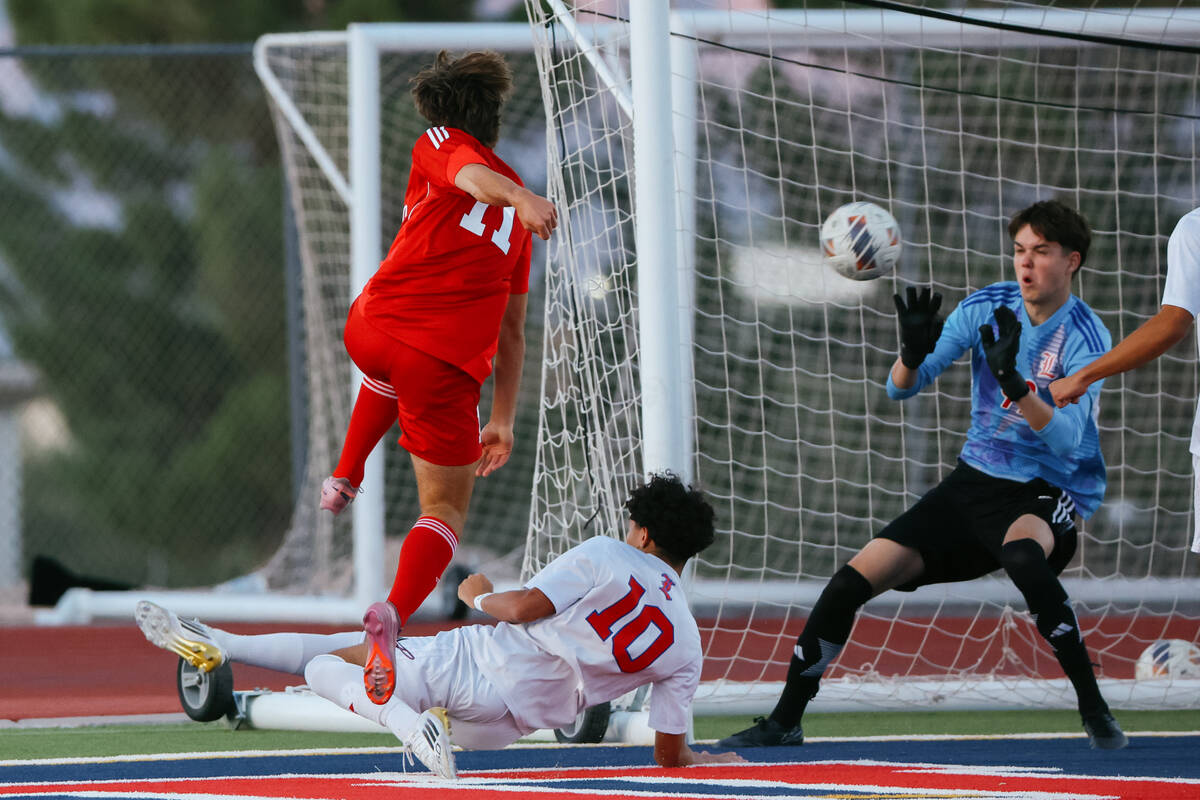 Coronado striker Gavin Flickinger (11) makes a successful shot on goal against Liberty goalkeep ...