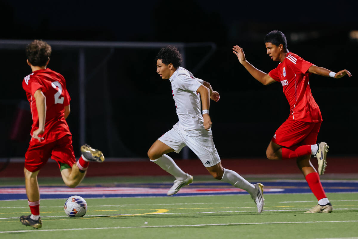 Liberty striker Justin Gilliland (10) dribbles toward the goal, pursued by Coronado defenders B ...