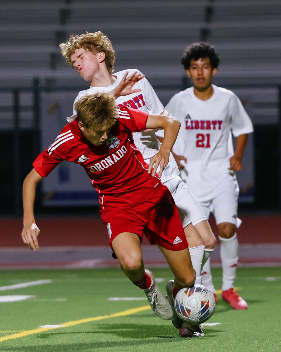 Coronado midfielder Cy Adams (8) and Liberty forward Hudson Albaugh (7) collide while going aft ...