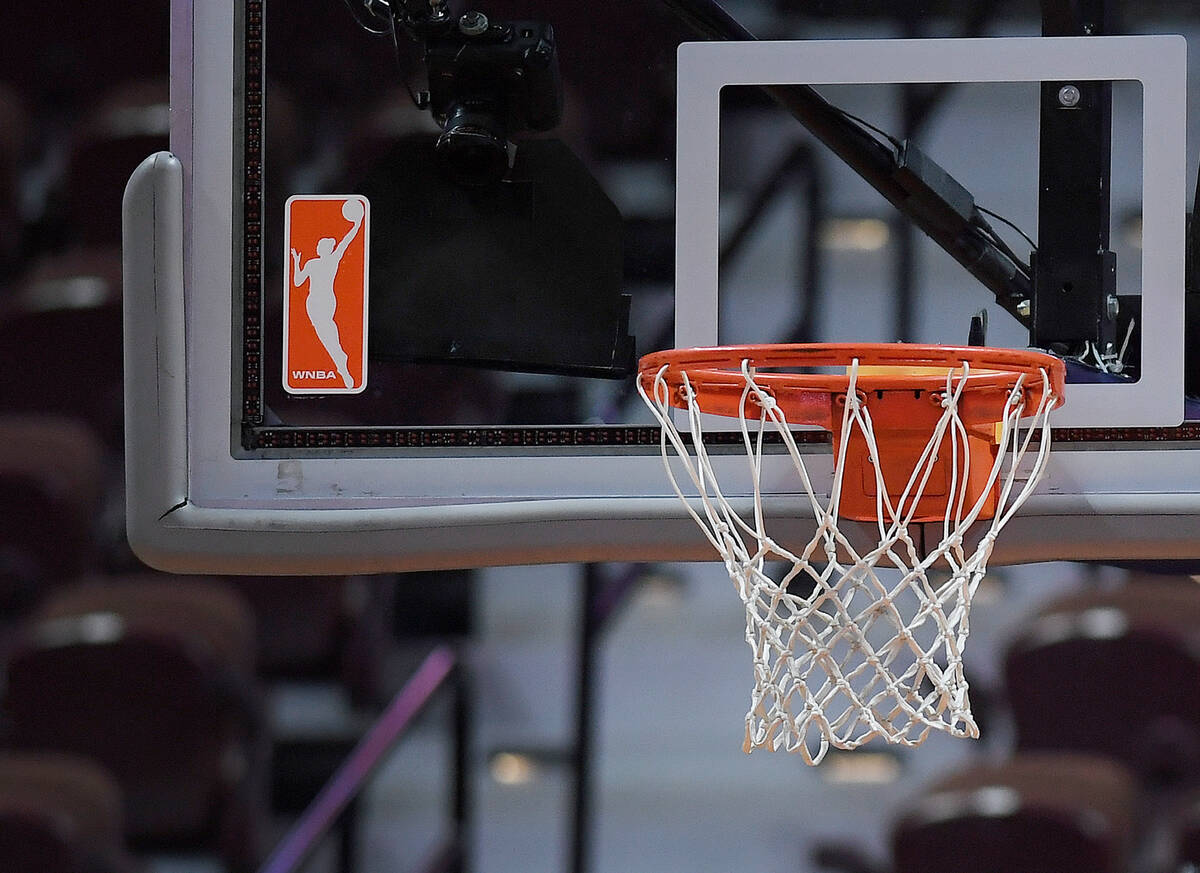 FILE - The WNBA logo and hoop are seen at a WNBA basketball game at Mohegan Sun Arena, Tuesday, ...