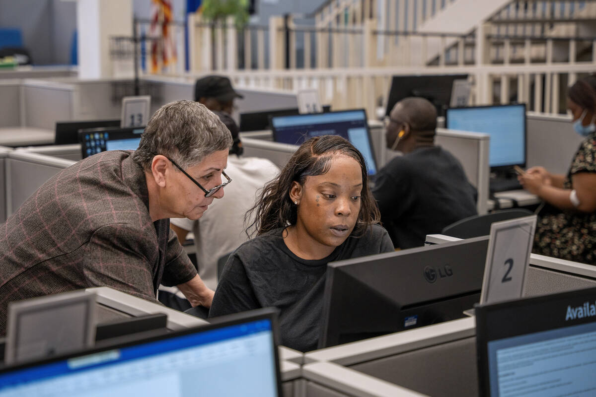 Administrative assistant Zahra Modjarrad helps job seekers complete tasks on the computer at Em ...