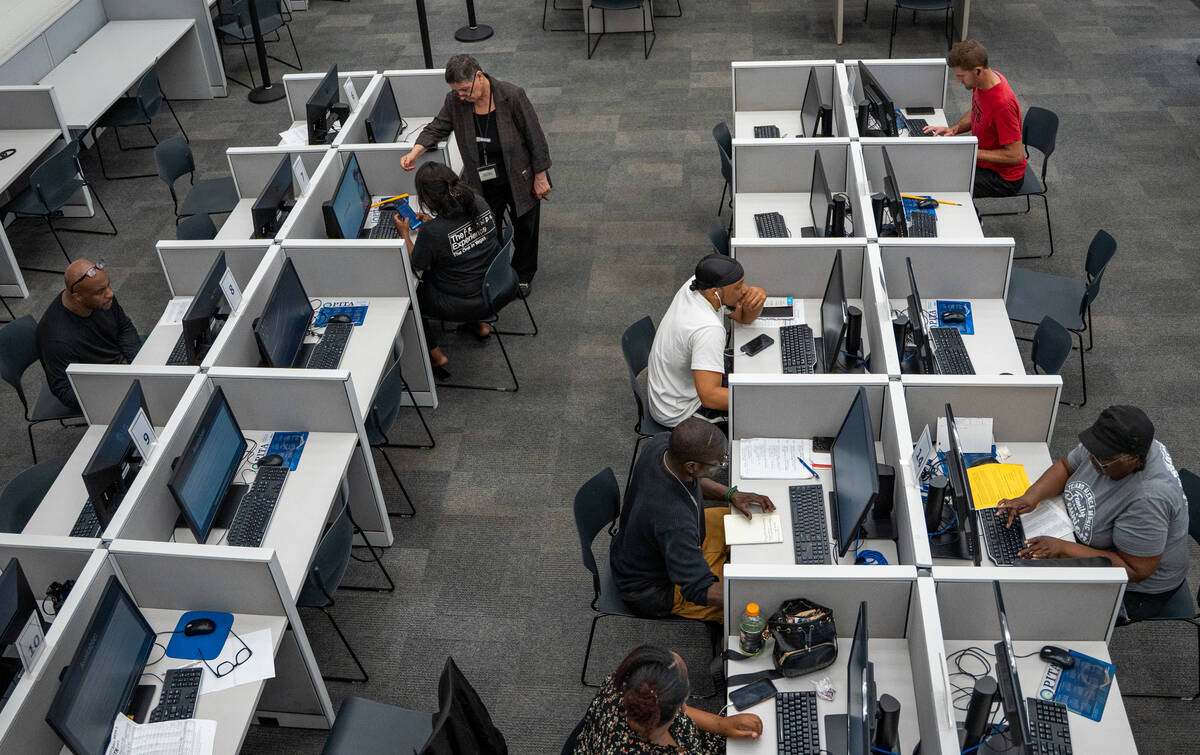 Administrative assistant Zahra Modjarrad helps job seekers complete tasks on the computer at Em ...