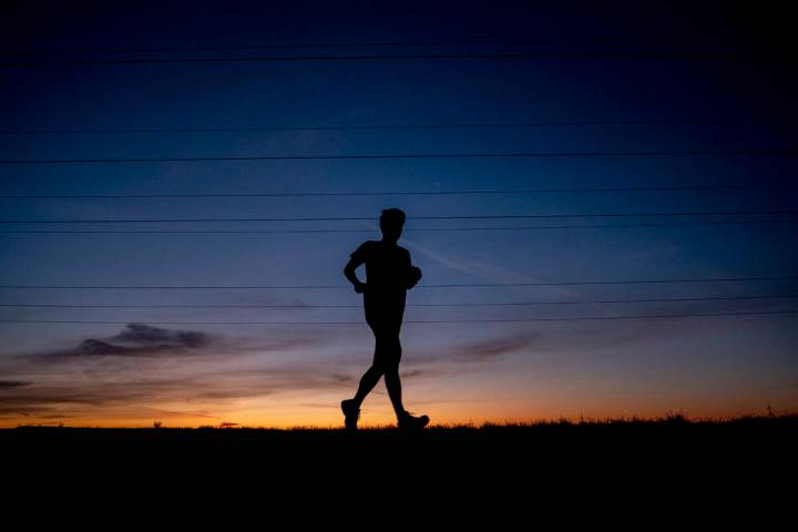 FILE - A man runs on a small road in the outskirts of Frankfurt, Germany, before sunrise on Sep ...