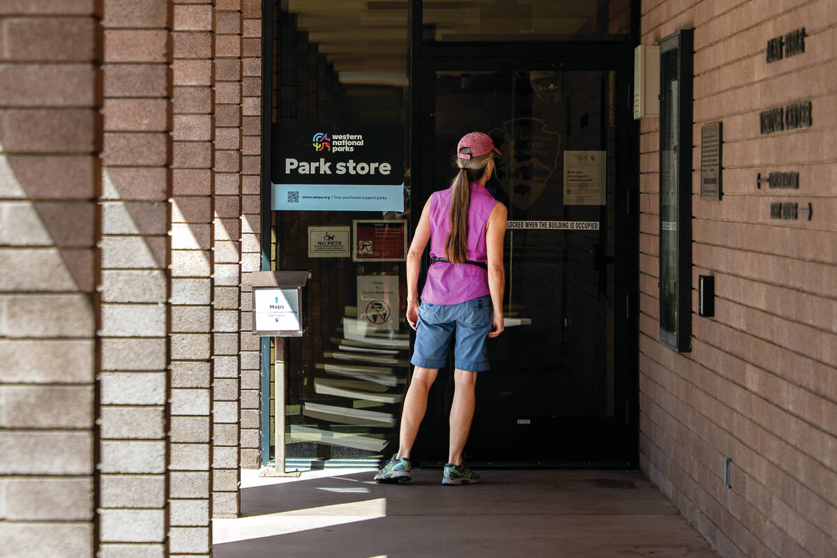 A visitor reads a sign notifying the public about the Lake Mead Visitors Center being closed be ...