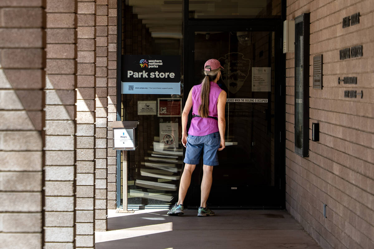 A visitor reads a sign notifying the public about the Lake Mead Visitors Center being closed be ...