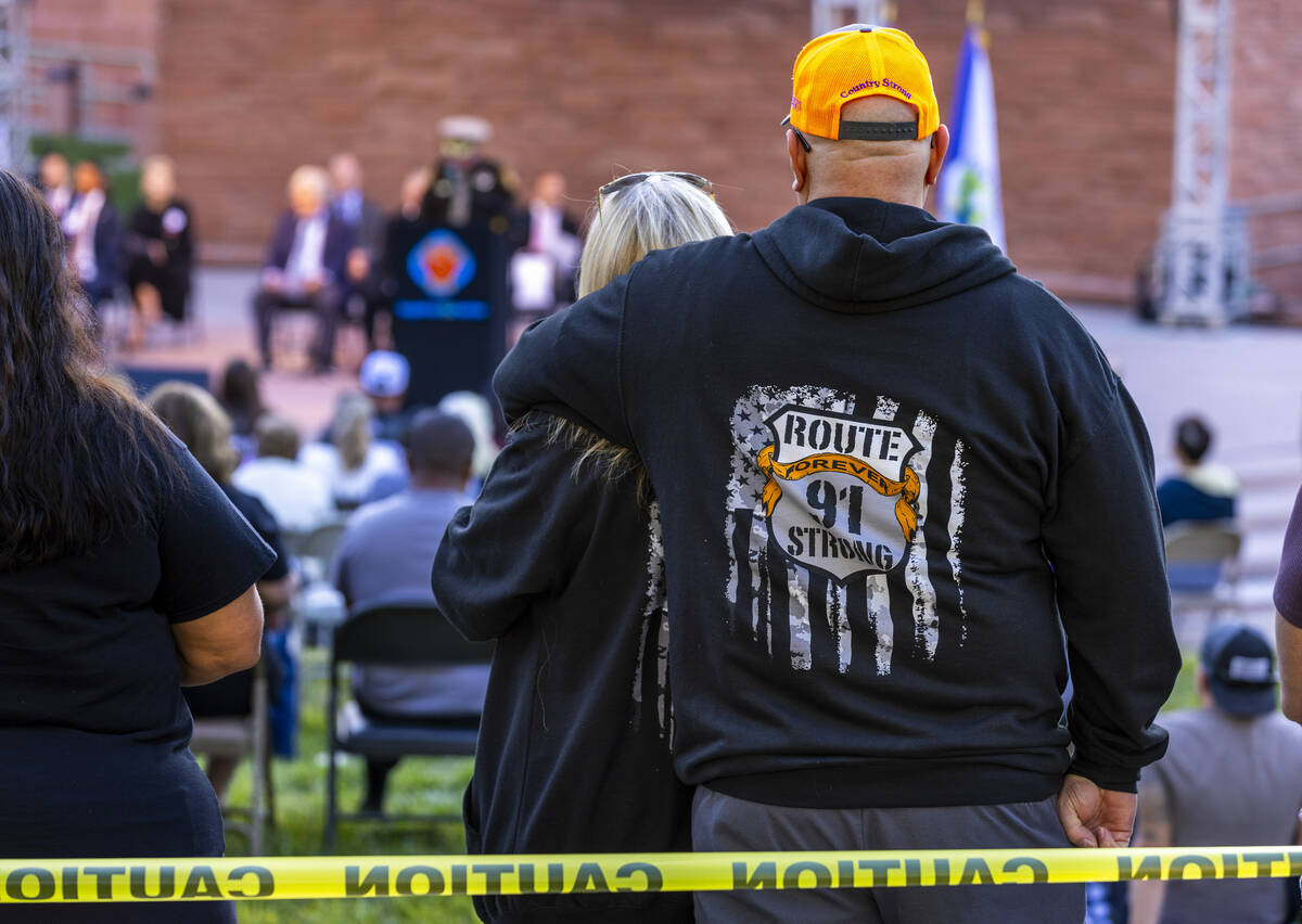 Participants stand as they listen to speakers during the 1 October Sunrise Remembrance service ...