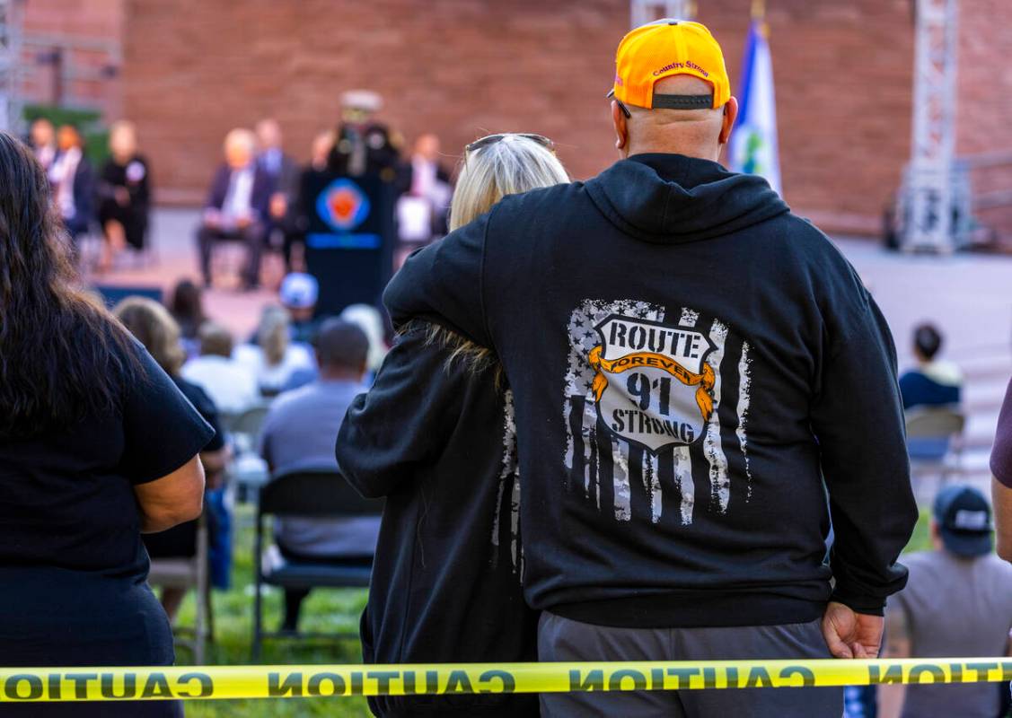 Participants stand as they listen to speakers during the 1 October Sunrise Remembrance service ...