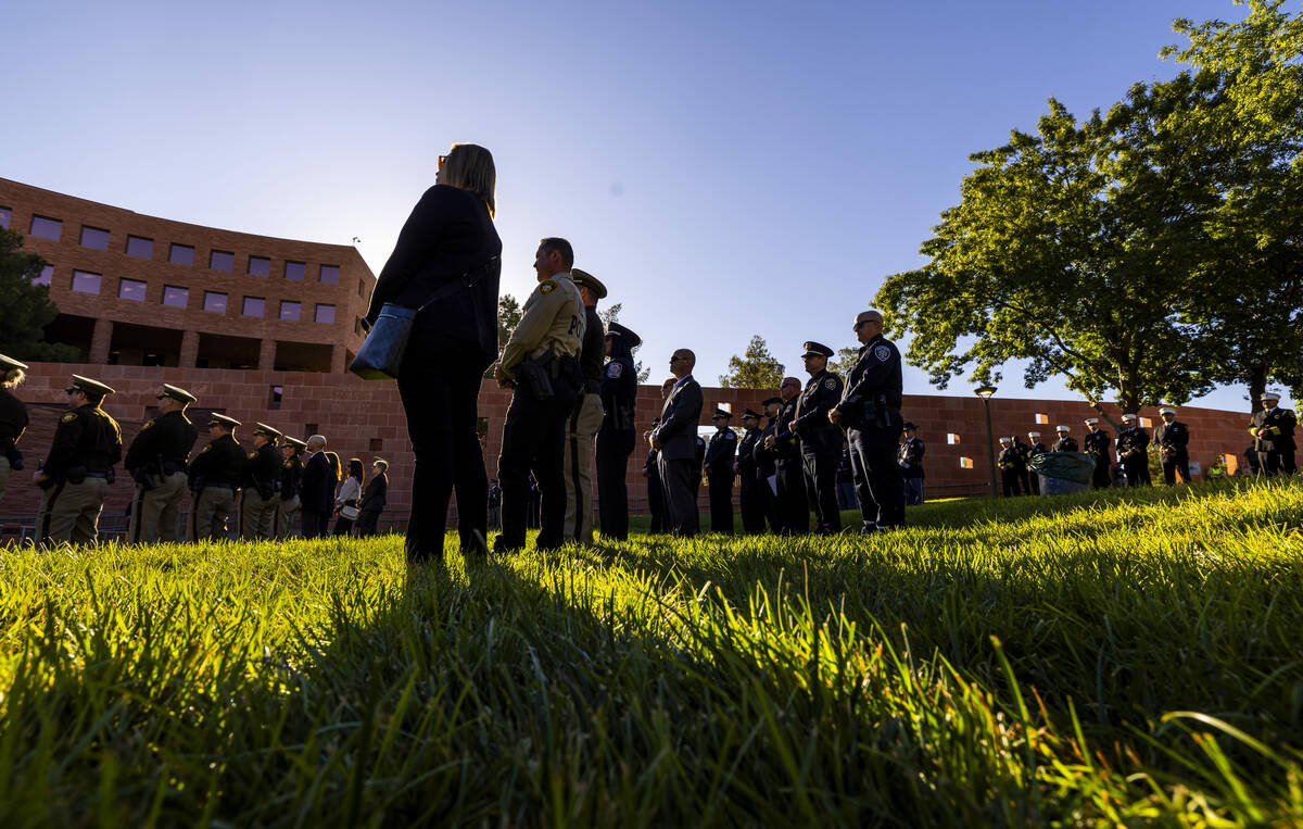 Police and fire personnel stand as they listen to speakers during the 1 October Sunrise Remembr ...