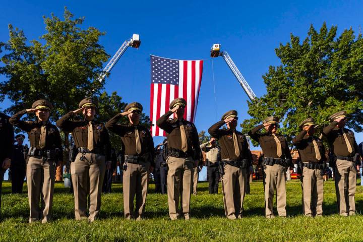 Police and firefighters salute as "Taps" is played by the Southern Nevada Multiagency ...