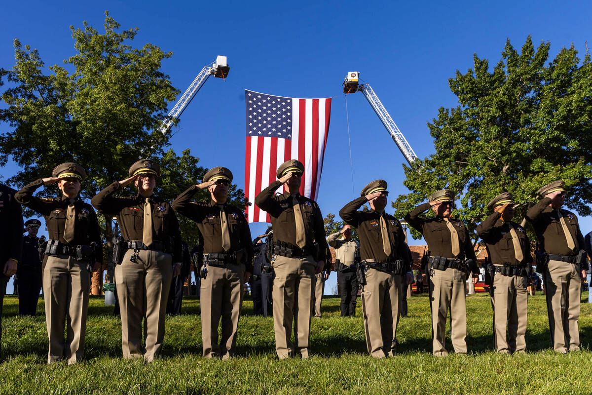 Police and firefighters salute as "Taps" is played by the Southern Nevada Multiagency ...