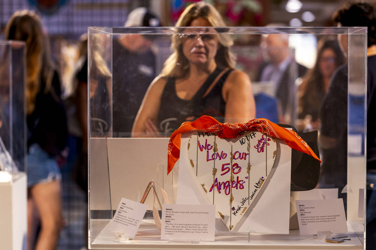 Visitors view the many items on display at the "Remembering October 1" exhibit follow ...
