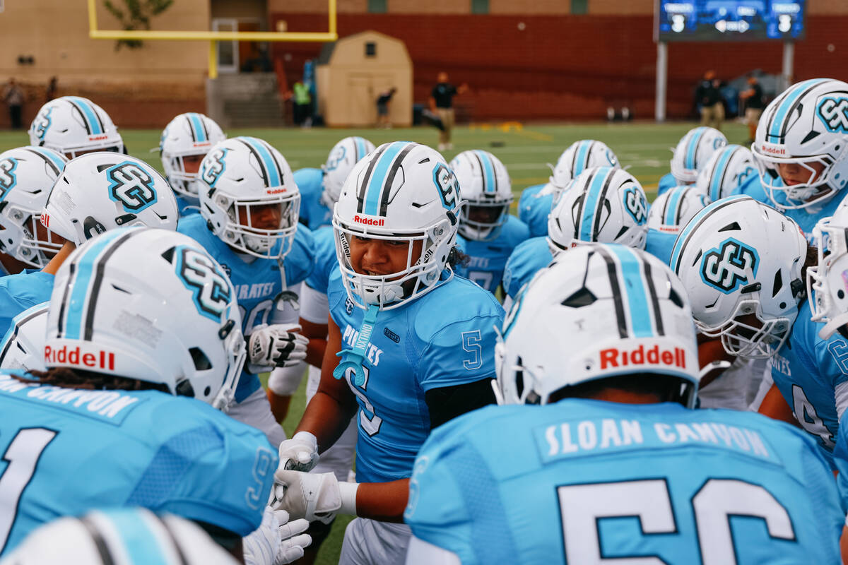 Sloan Canyon’s Kalepo Mose (5), middle, hypes up his team before playing against Spring ...
