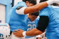 Sloan Canyon’s Kaizen Ayento-Rosa (28), center, prays with teammates before a football g ...
