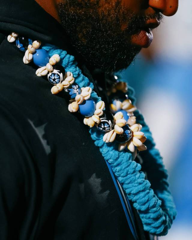 Sloan Canyon assistant coach JD Alexander wears leis with beads and shells while coaching a foo ...