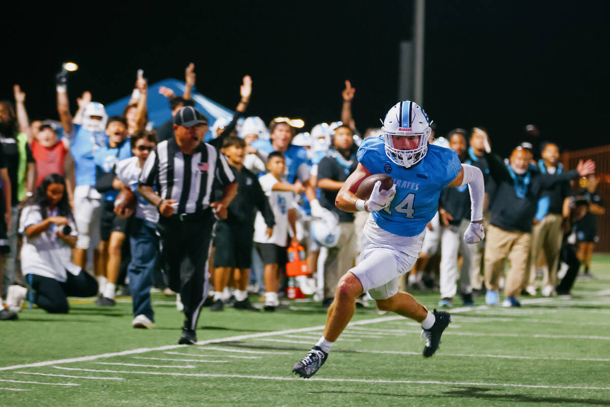 Sloan Canyon wide receiver Christian Rhodes (14) sprints toward the end zone as his team cheers ...