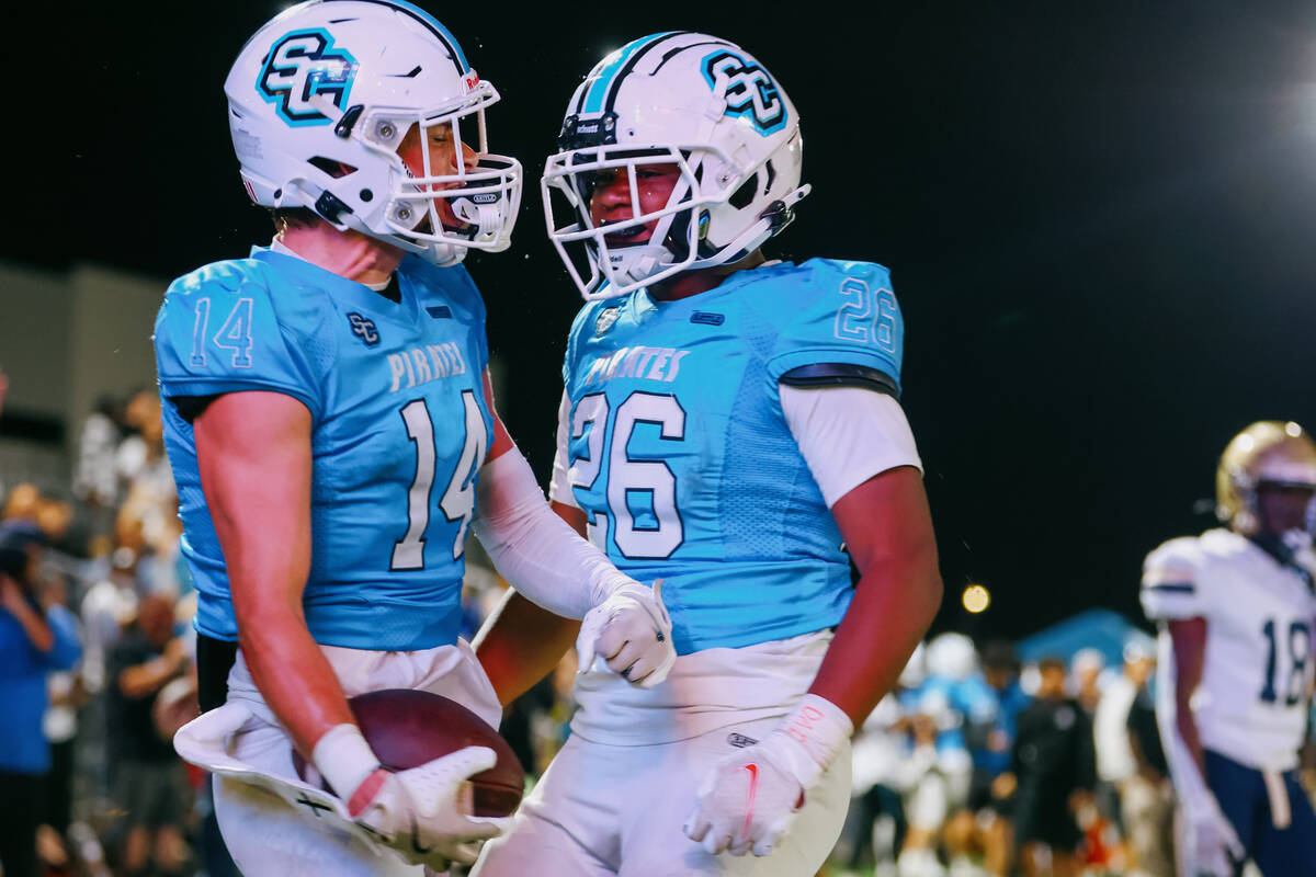 Sloan Canyon wide receiver Christian Rhodes (14) and running back Cameron Greene celebrate a to ...