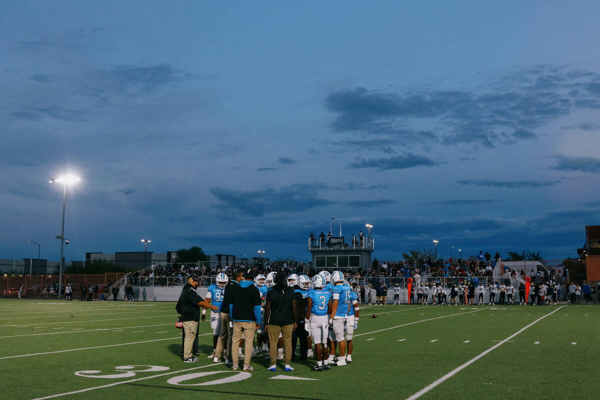 Sloan Canyon’s football team huddles during a break in the action of a game on Friday, S ...