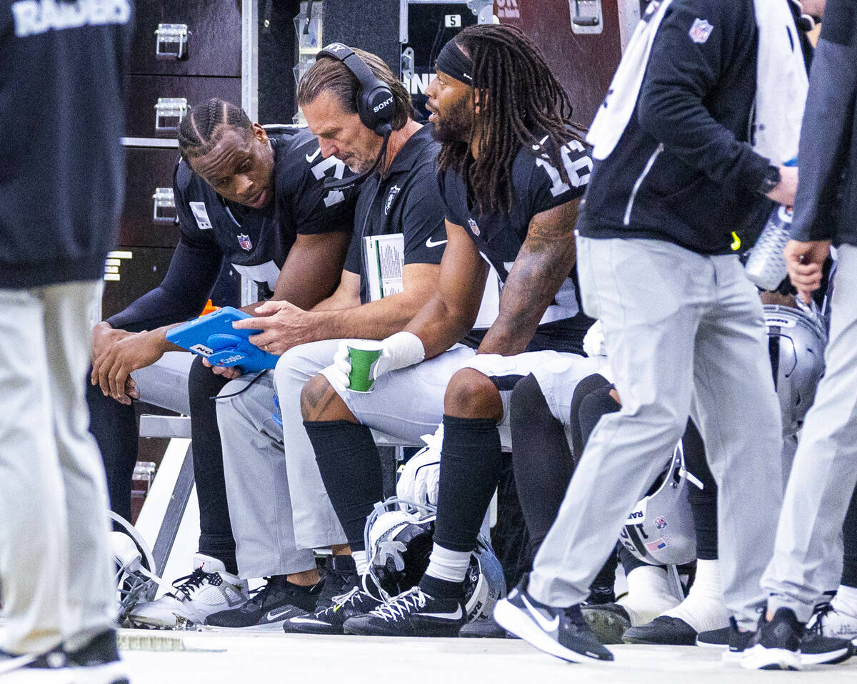 Raiders quarterback Geno Smith (7) talks with quarterback's coach Greg Olson with wide re ...