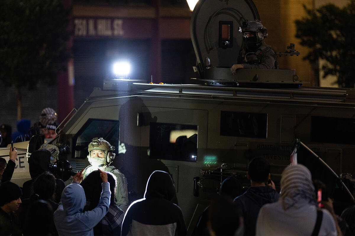 ICE officers try to leave the scene after performing a raid but protesters block their way in C ...