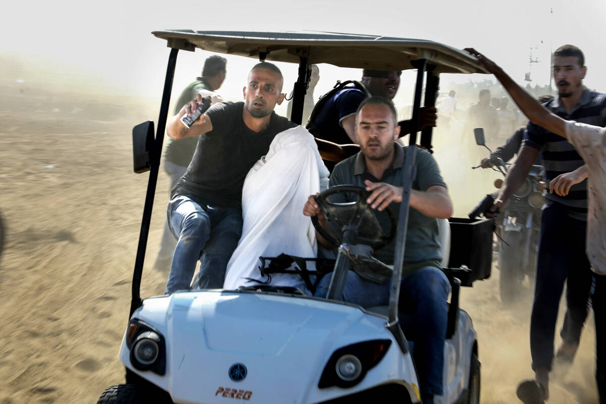 Palestinians transport a person to Gaza after kidnapping them from a kibbutz in Israel near the ...