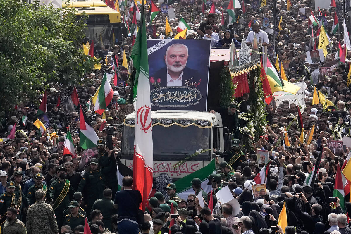 FILE - Iranians follow a truck carrying the coffins of Hamas leader Ismail Haniyeh and his body ...