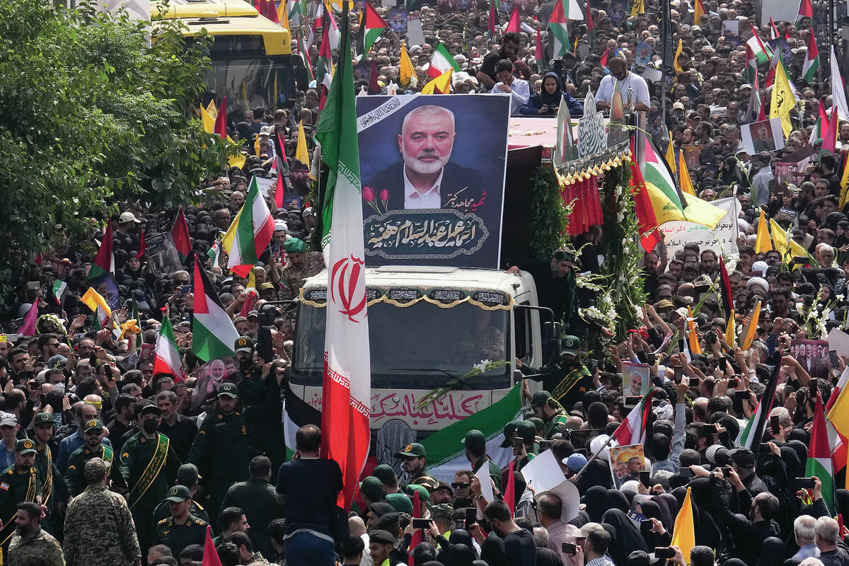 FILE - Iranians follow a truck carrying the coffins of Hamas leader Ismail Haniyeh and his body ...