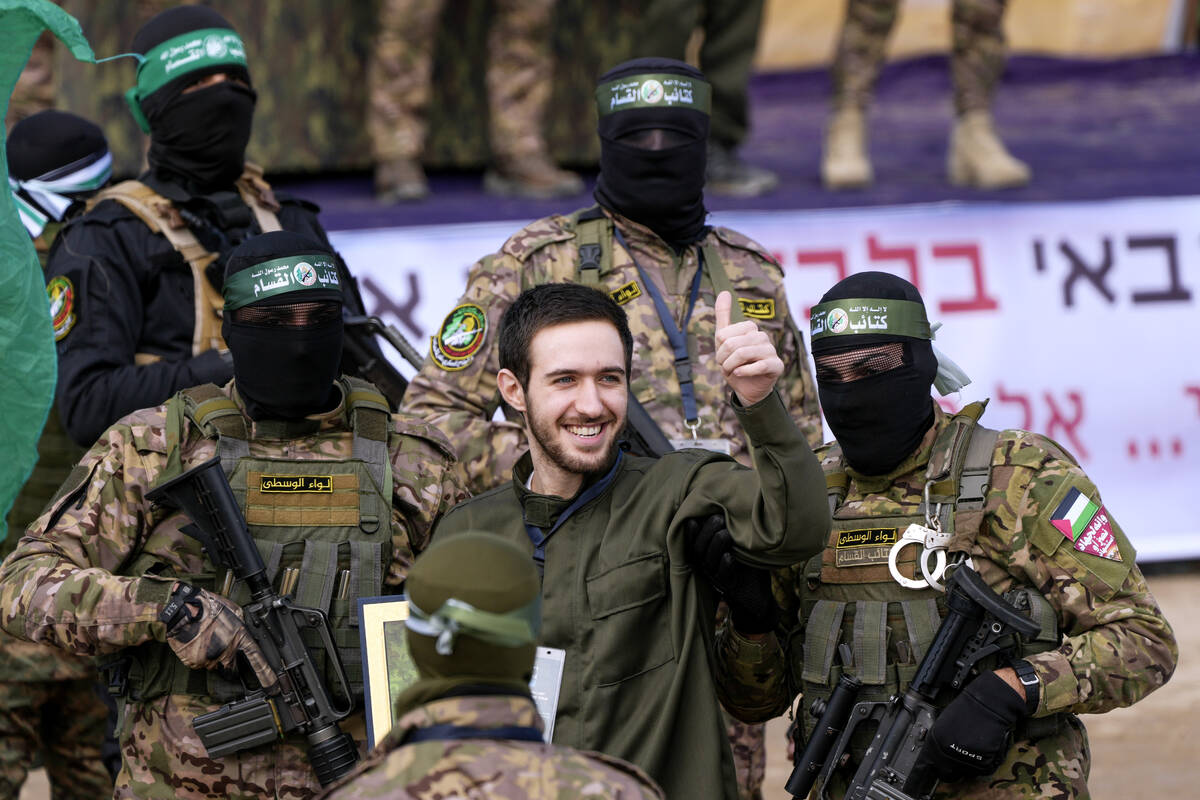 Israeli hostage Omer Shem, centre, is escorted by Hamas fighters before being handed over to th ...