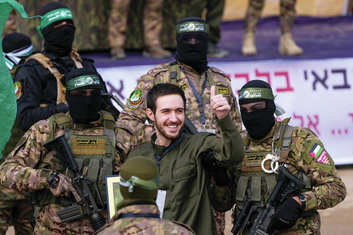 Israeli hostage Omer Shem, centre, is escorted by Hamas fighters before being handed over to th ...