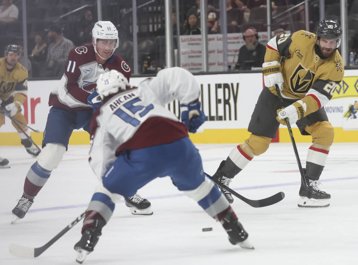 Golden Knights left wing Brandon Saad (20) passes the puck between Colorado Avalanche center Br ...