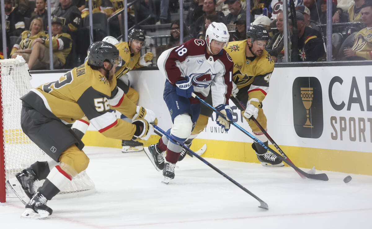 Colorado Avalanche center Jack Drury (18) tries to keep the puck from Golden Knights defenseman ...