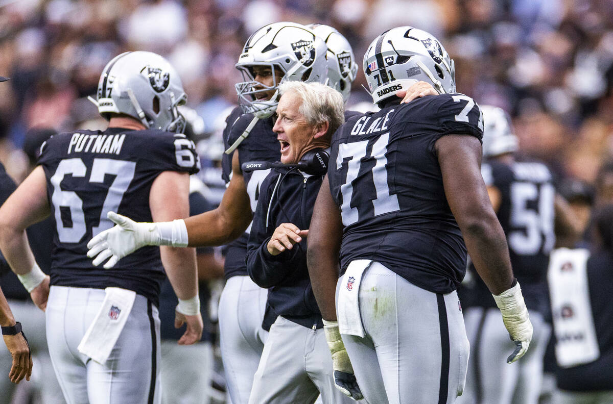Raiders head coach Pete Carroll congratulates Raiders offensive tackle DJ Glaze (71) and others ...