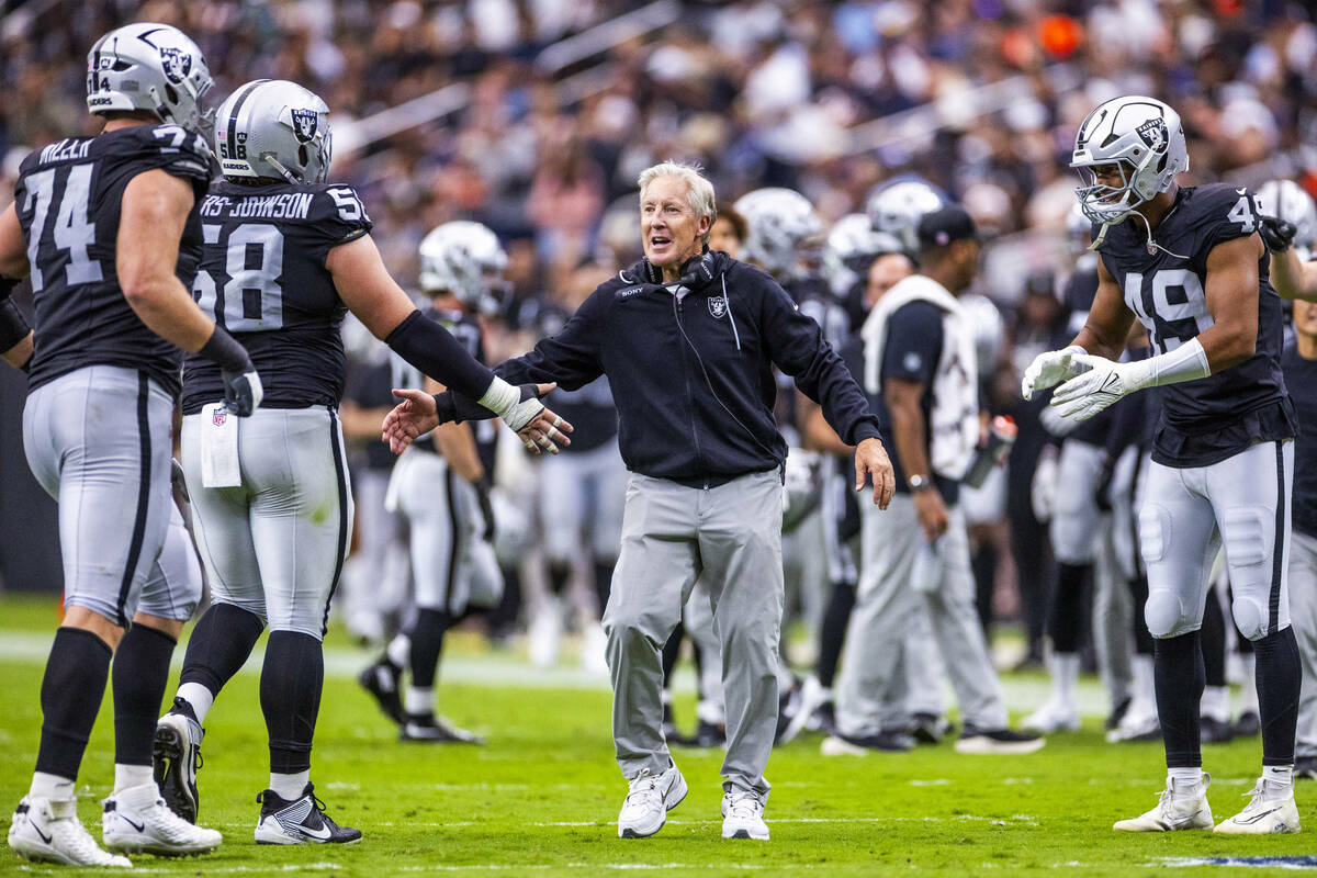 Raiders head coach Pete Carroll congratulates Raiders center Jackson Powers-Johnson (58) and of ...