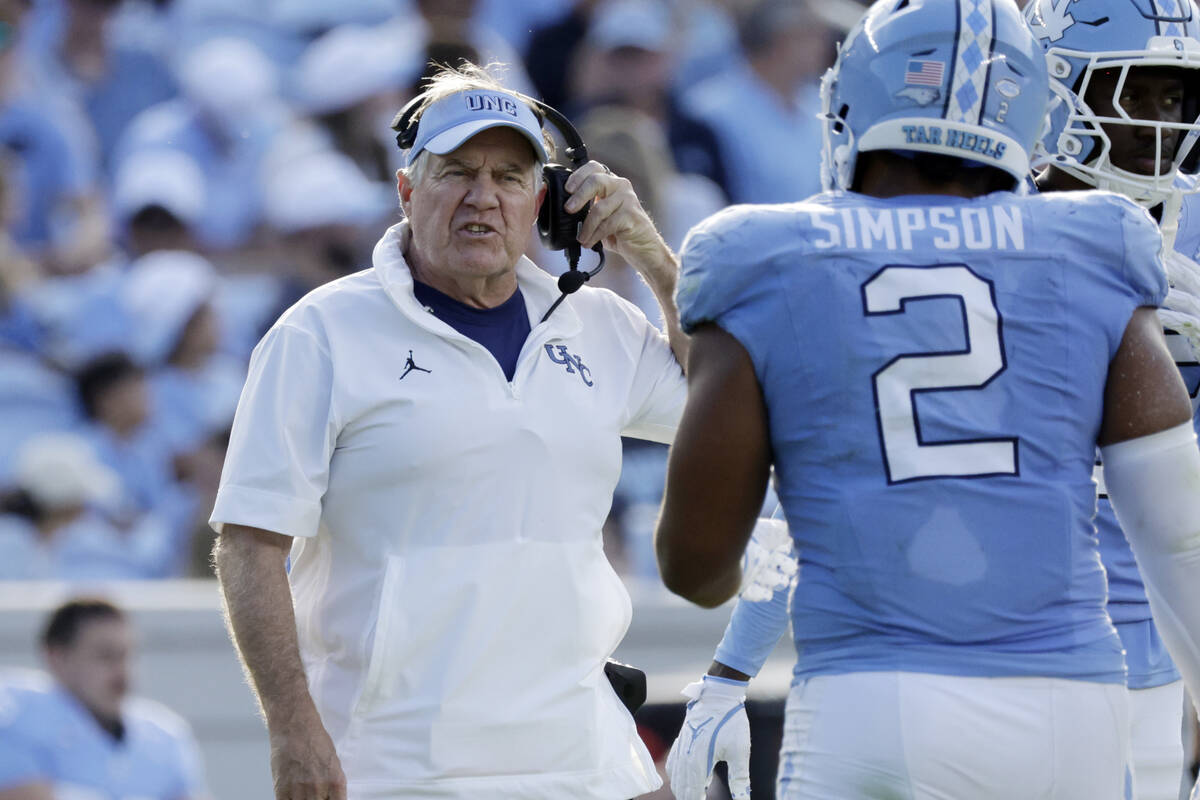 North Carolina head coach Bill Belichick talks to North Carolina linebacker Andrew Simpson (2) ...
