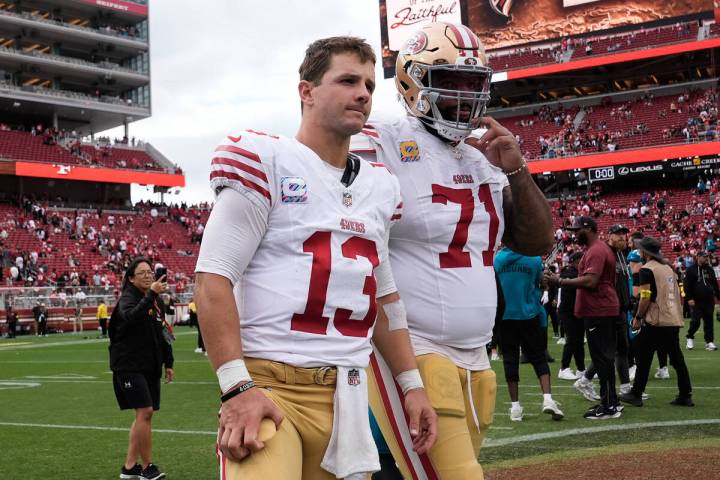 San Francisco 49ers quarterback Brock Purdy (13) and offensive tackle Trent Williams (71) walk ...