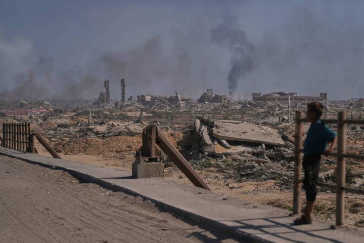 A displaced Palestinian boy looks at smoke rising into the sky following an Israeli military st ...