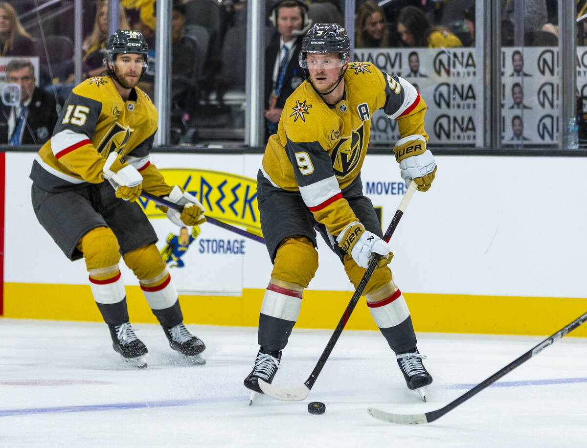 Golden Knights center Jack Eichel (9) looks to pass with defenseman Noah Hanifin (15) trailing ...