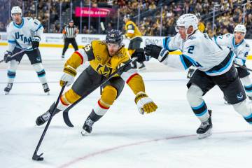 Golden Knights defenseman Noah Hanifin (15) gets a stick from Utah Mammoth defenseman Olli M&#x ...