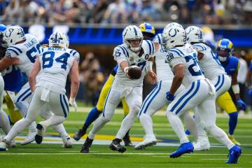 Indianapolis Colts quarterback Daniel Jones (17) hands off to running back Jonathan Taylor (28) ...