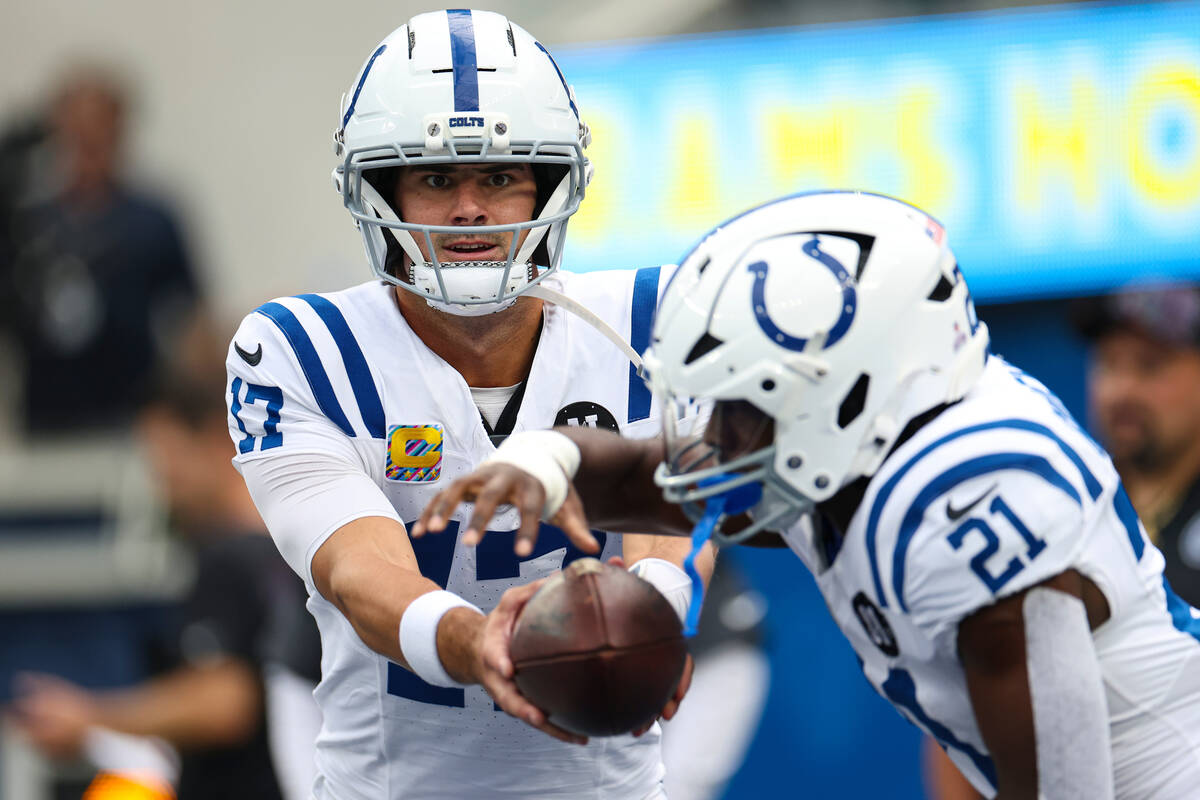 Indianapolis Colts quarterback Daniel Jones (17) hands off to running back DJ Giddens (21) befo ...
