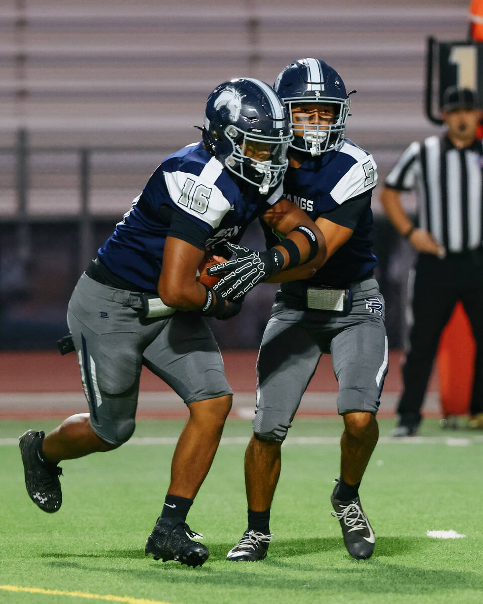 Shadow Ridge’s Isaiah Ruiz (5) hands the ball off to Isaiah Jones (16) during the game o ...