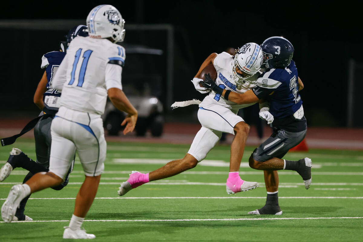Centennial wide receiver Jayden Thomas (1) slams into Shadow Ridge’s Ula Cox (3) while c ...