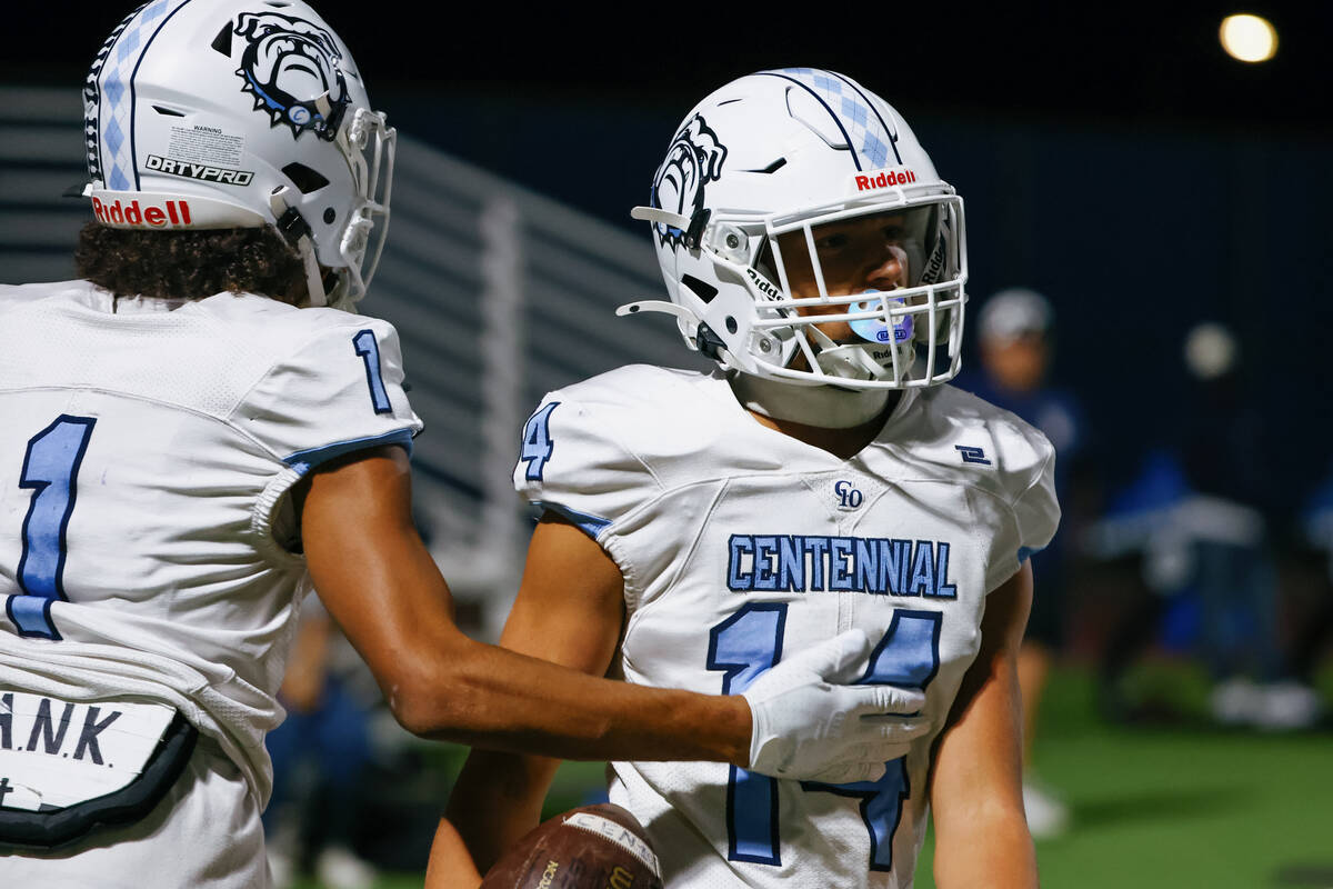 Centennial wide receiver Jayden Thomas (1), left, congratulates teammate Brogan Church (14) for ...