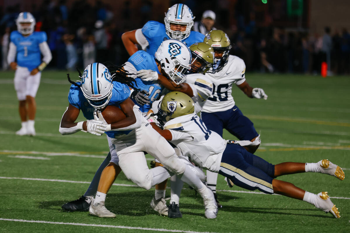 Spring Valley defensive back Legend Duncantel (12) tackles Sloan Canyon running back Jermaine W ...