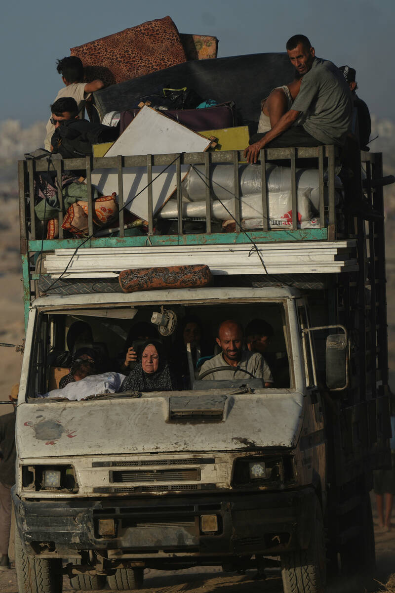 Displaced Palestinians flee northern Gaza carrying their belongings along the coastal road near ...