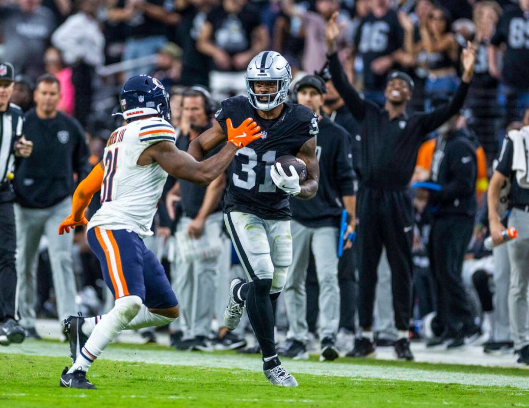 Raiders running back Raheem Mostert (31) looks to get past Chicago Bears free safety Kevin Byar ...