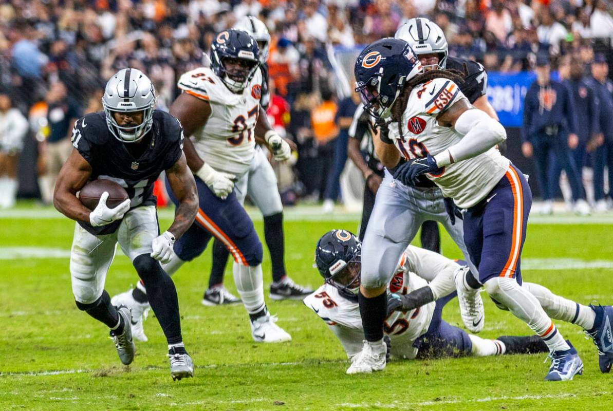 Raiders running back Raheem Mostert (31) looks for room to run as Chicago Bears defenders move ...