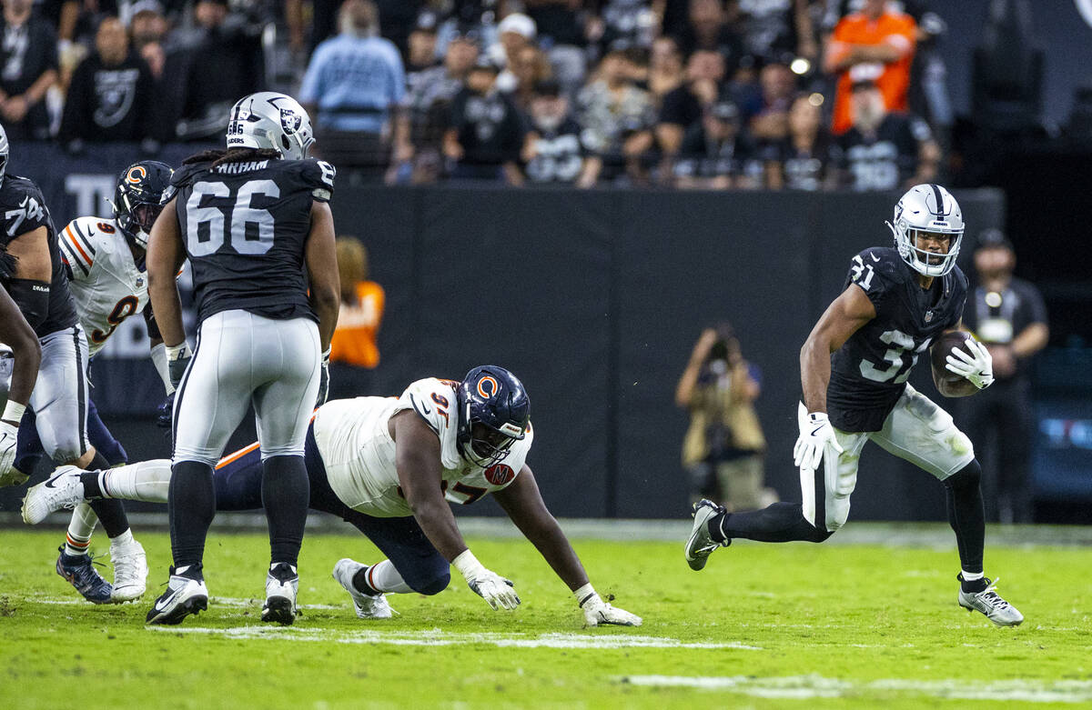 Raiders running back Raheem Mostert (31) turns the corner as Chicago Bears defensive tackle And ...