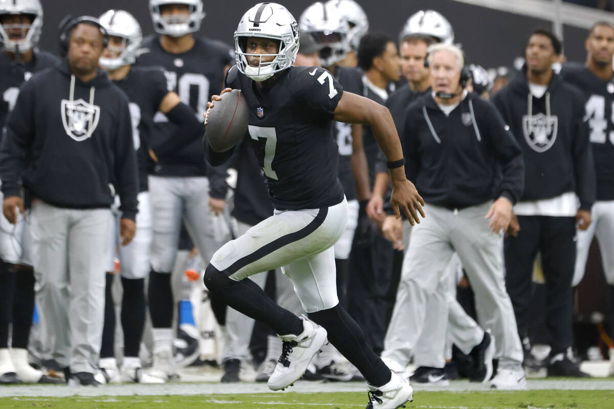 Raiders quarterback Geno Smith (7) runs with the ball for a first down during an NFL football g ...